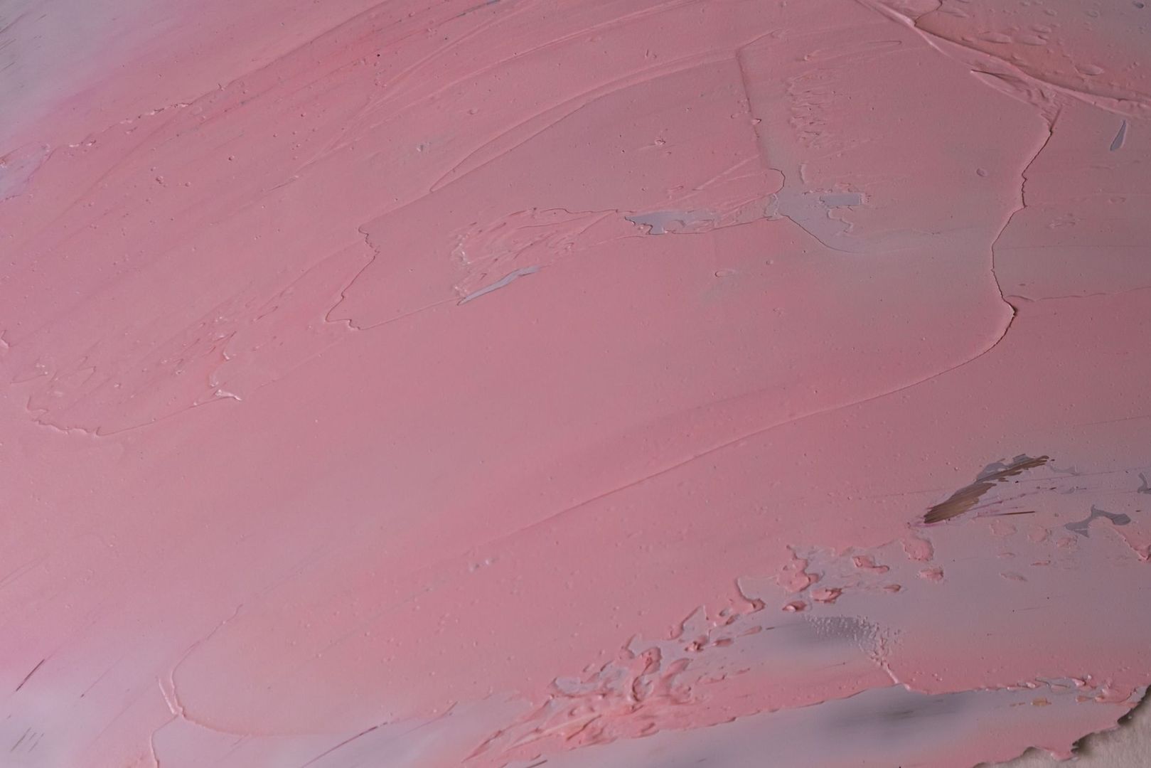 Close-up van een roze, geschilderd oppervlak met zichtbare penseelstreken